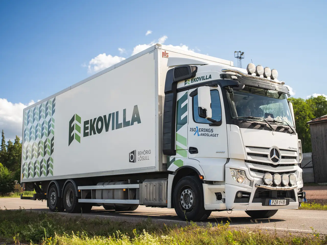 Ekovillas lastbil med logotyp mot blå himmel